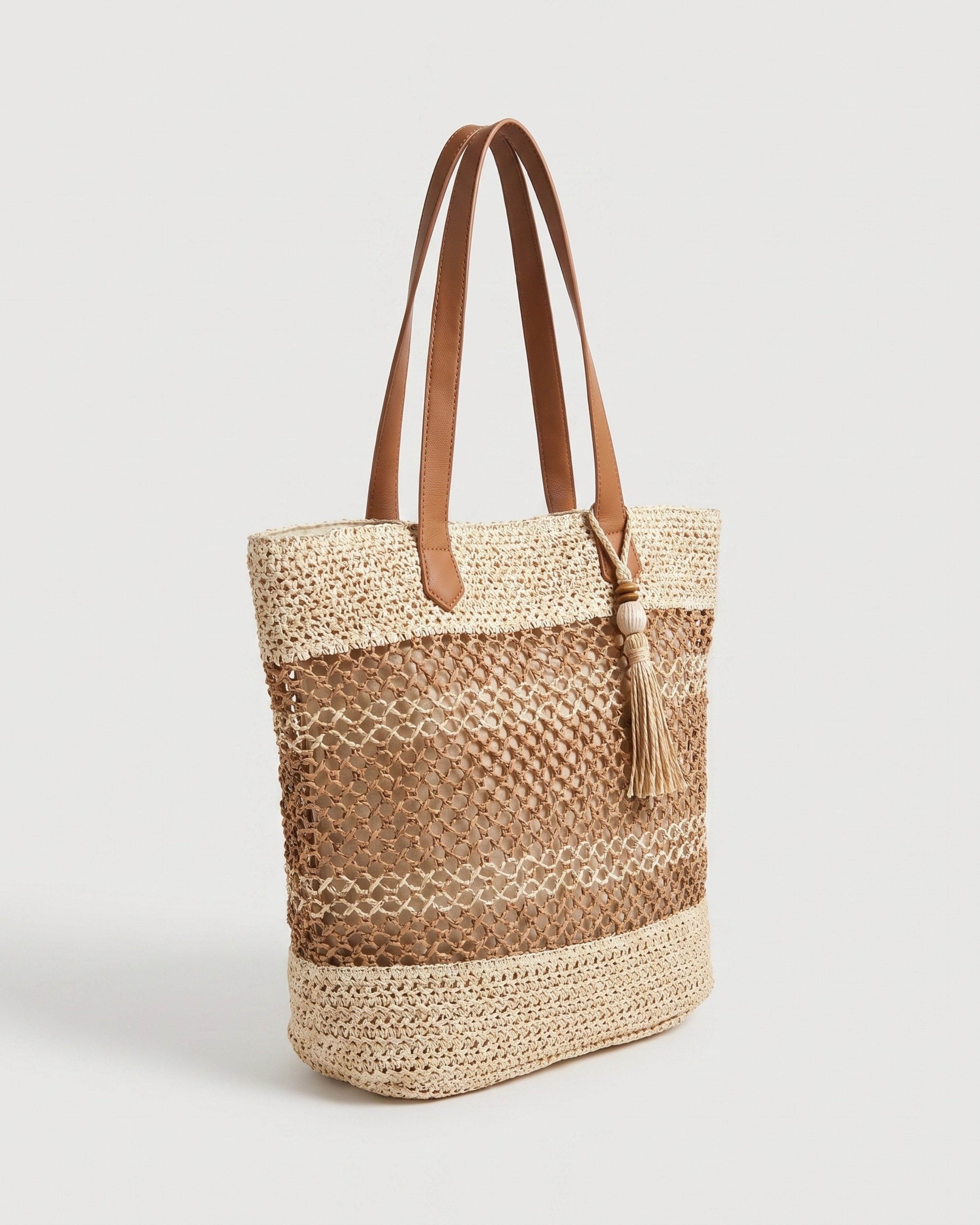 Tasseled Straw Tote Bag in beige — three-quarter view, RABUKO