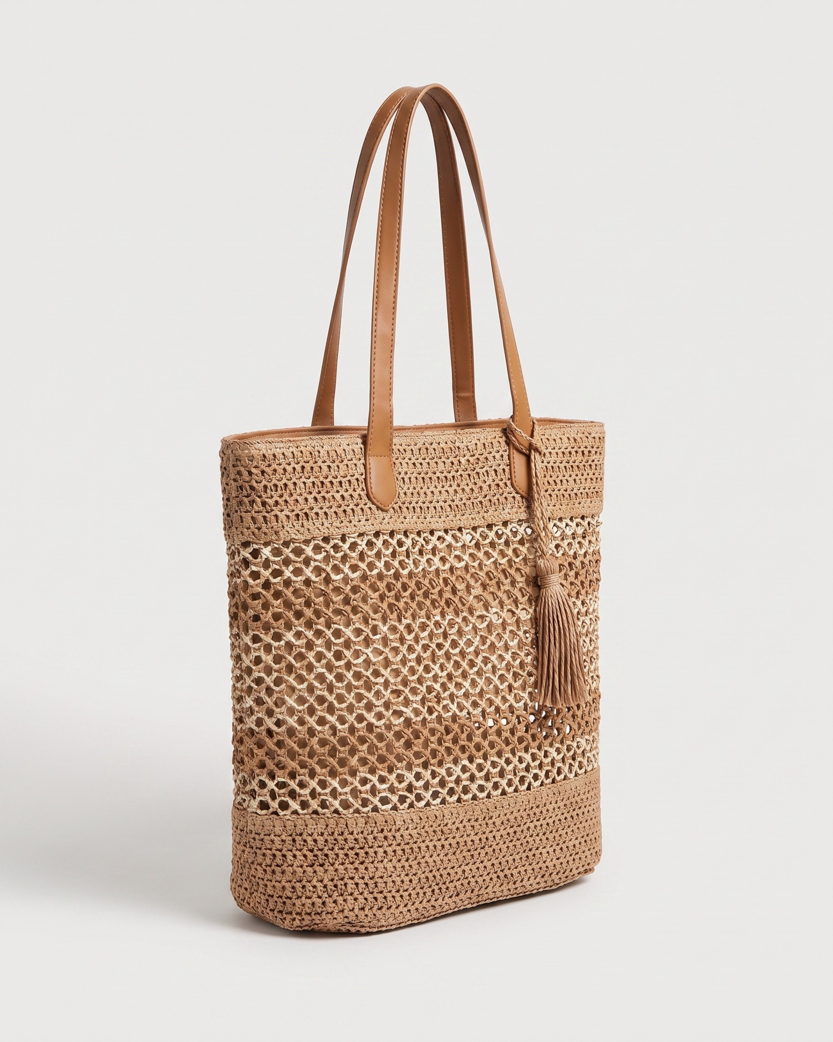 Tasseled Straw Tote Bag in brown — three-quarter view, RABUKO