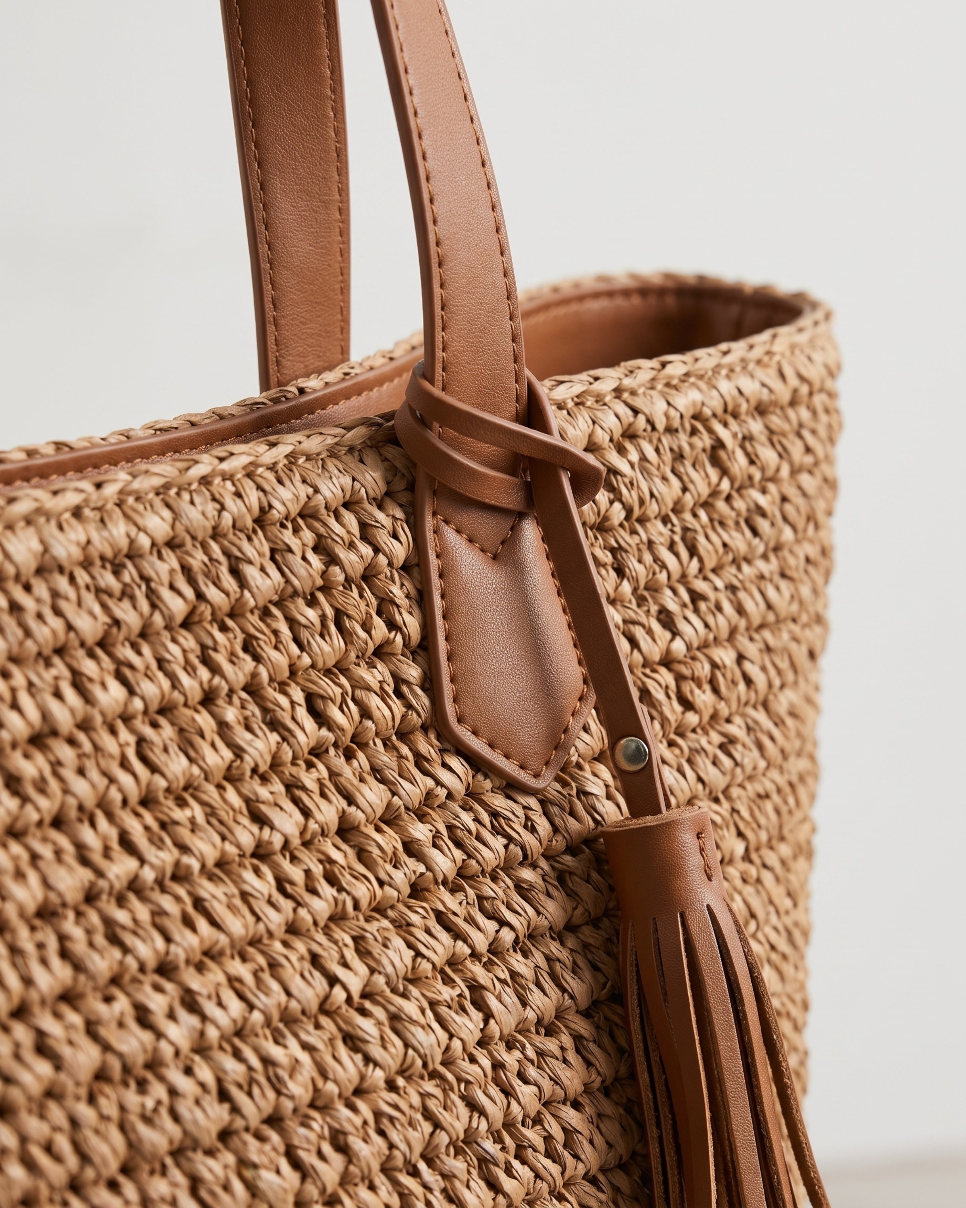 Tasseled Straw Tote Bag in brown — tassel detail, RABUKO
