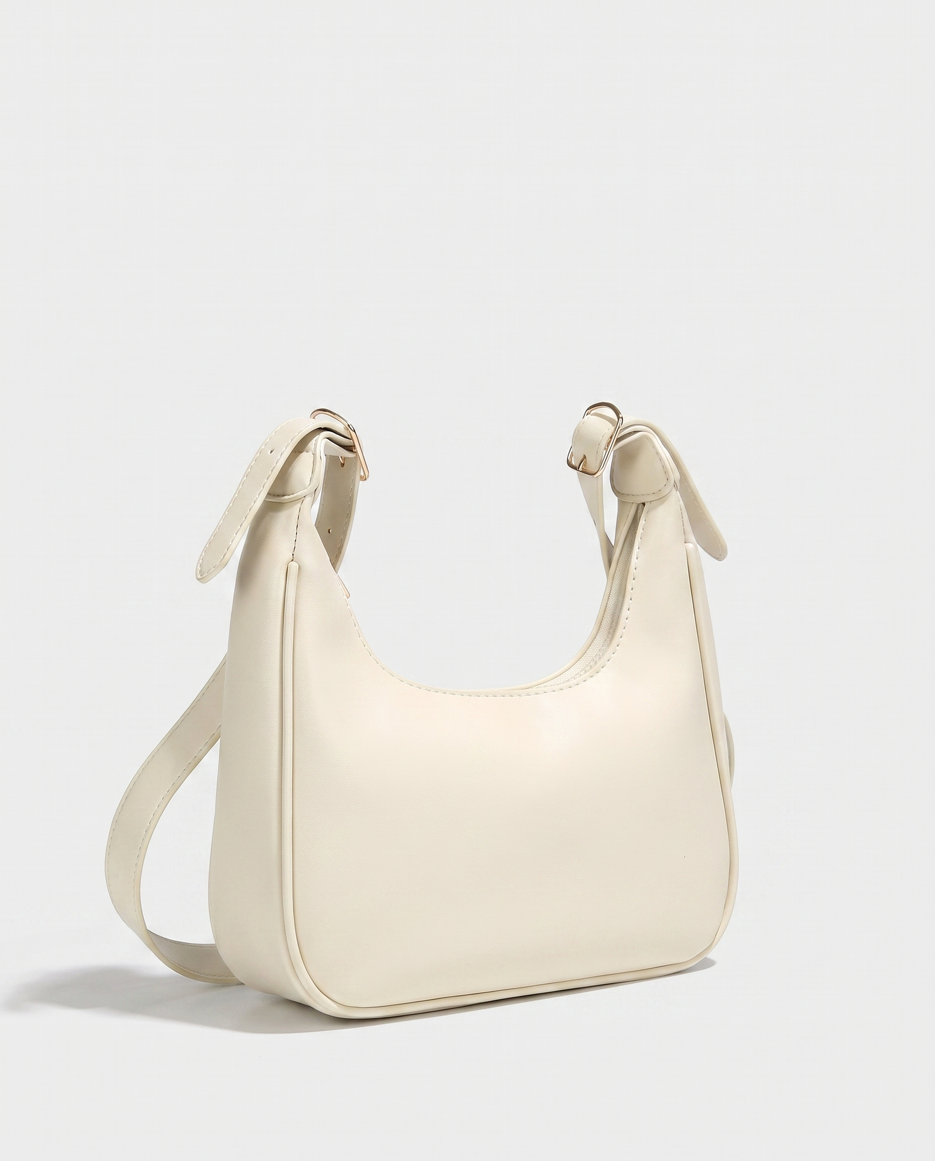 Crescent mini crossbody bag in white — three-quarter view, RABUKO