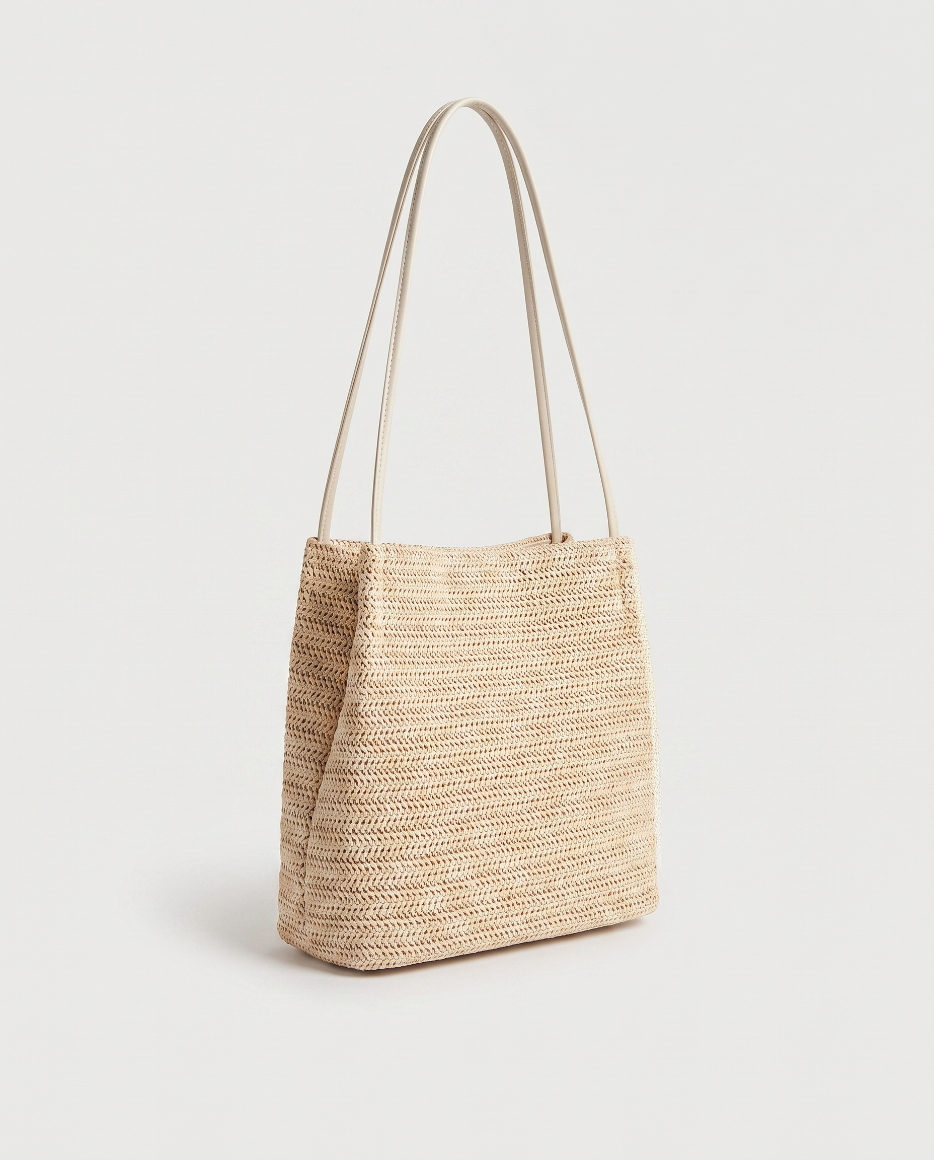 Mini Handwoven Straw Tote in light beige — three-quarter view, RABUKO