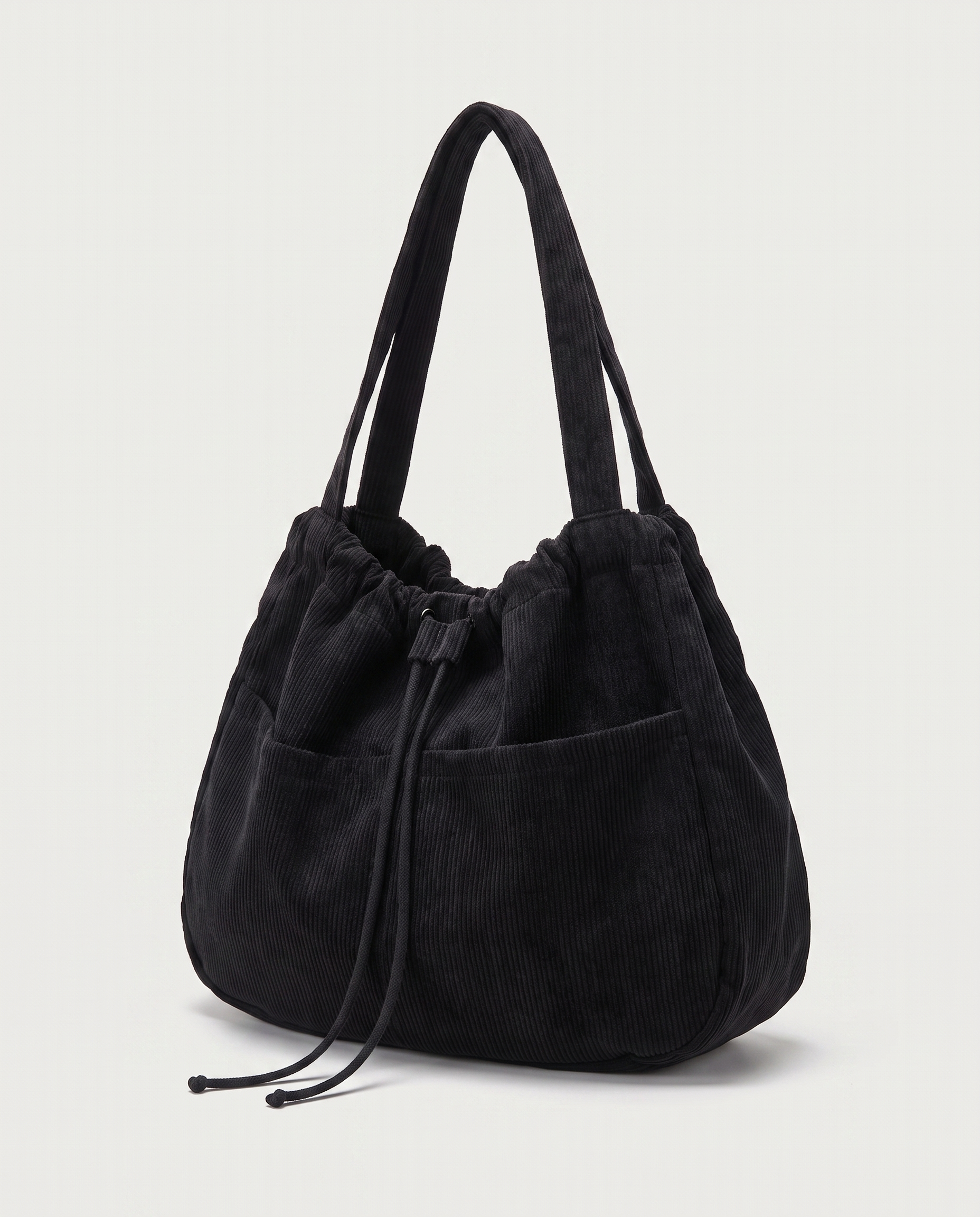 Corduroy drawstring bag in black — three-quarter view, RABUKO
